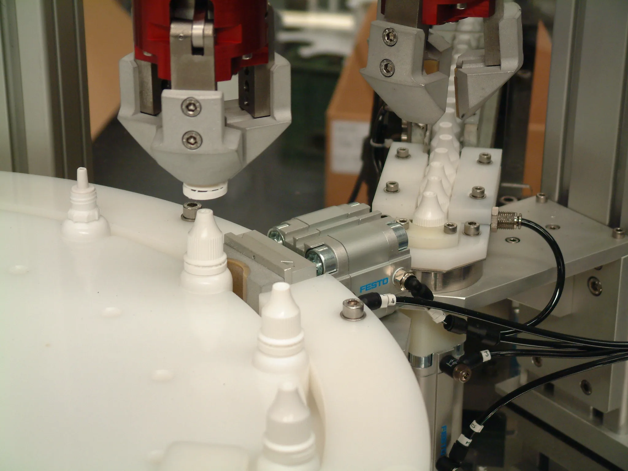 CC1160 Automatic Filling & Capping Machine with crimp head applying caps to Nasaleze nasal spray bottles.