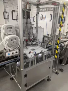 Mini Mono Twin Head Precision Liquid Filling and Capping Machine, setup within a life science production facility.