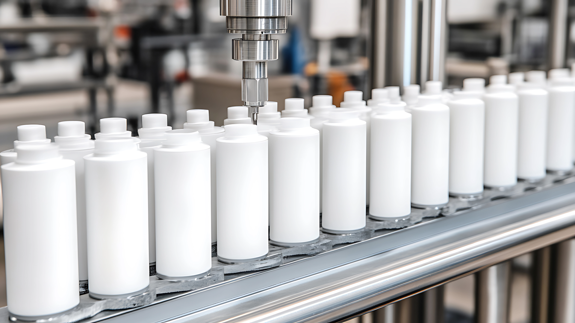 Tall white bottles being filled and capped on a production line.