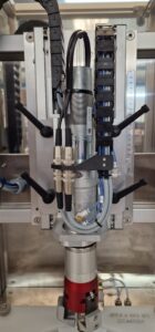 Close-up view of CC1100 Semi-Automatic Capper applying caps to bottles with precise alignment.