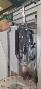 CC1100 Benchtop Capper automatically sealing bottles on a production line with consistent torque accuracy.