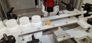 CC570 Semi Automatic Cap Closure Machine, Showing the automatic gating system to control bottle flow into the machine.