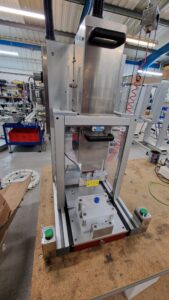 CC1440 Benchtop Capping Machine, showing loaded capping machine awaiting to tighten the cap down on a square vial.