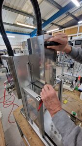 CC1440 Benchtop Capper, Showing user adjusting the height of the capper for a different product.